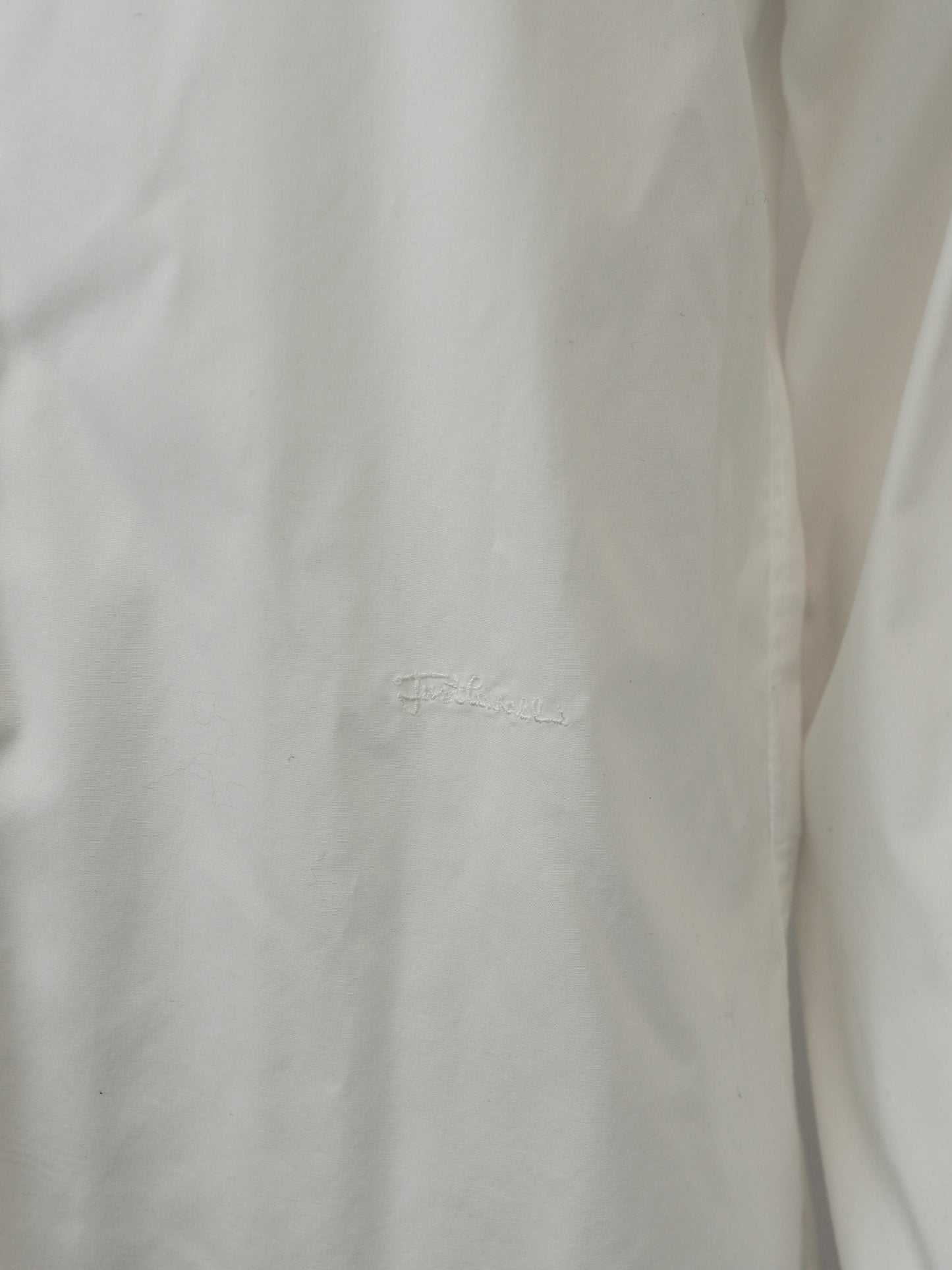 A vintage Roberto cavalli white long-sleeve button-down shirt with black and silver patterned stud trim on the collar and cuffs