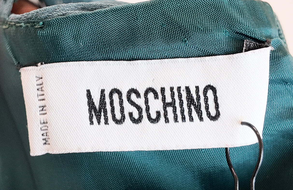 Moschino label on a teal fabric background