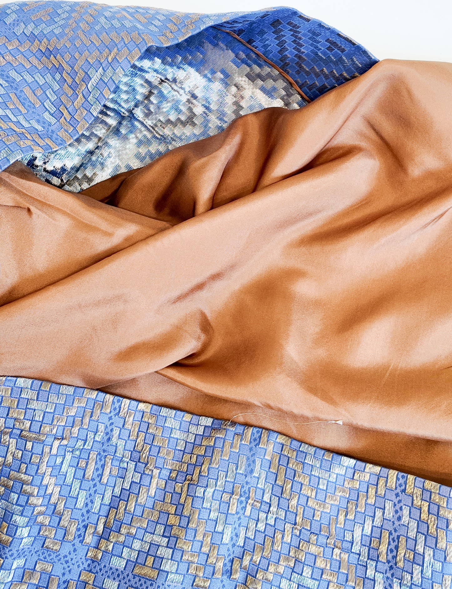 Close-up of brown fabric on a blue mosaic background