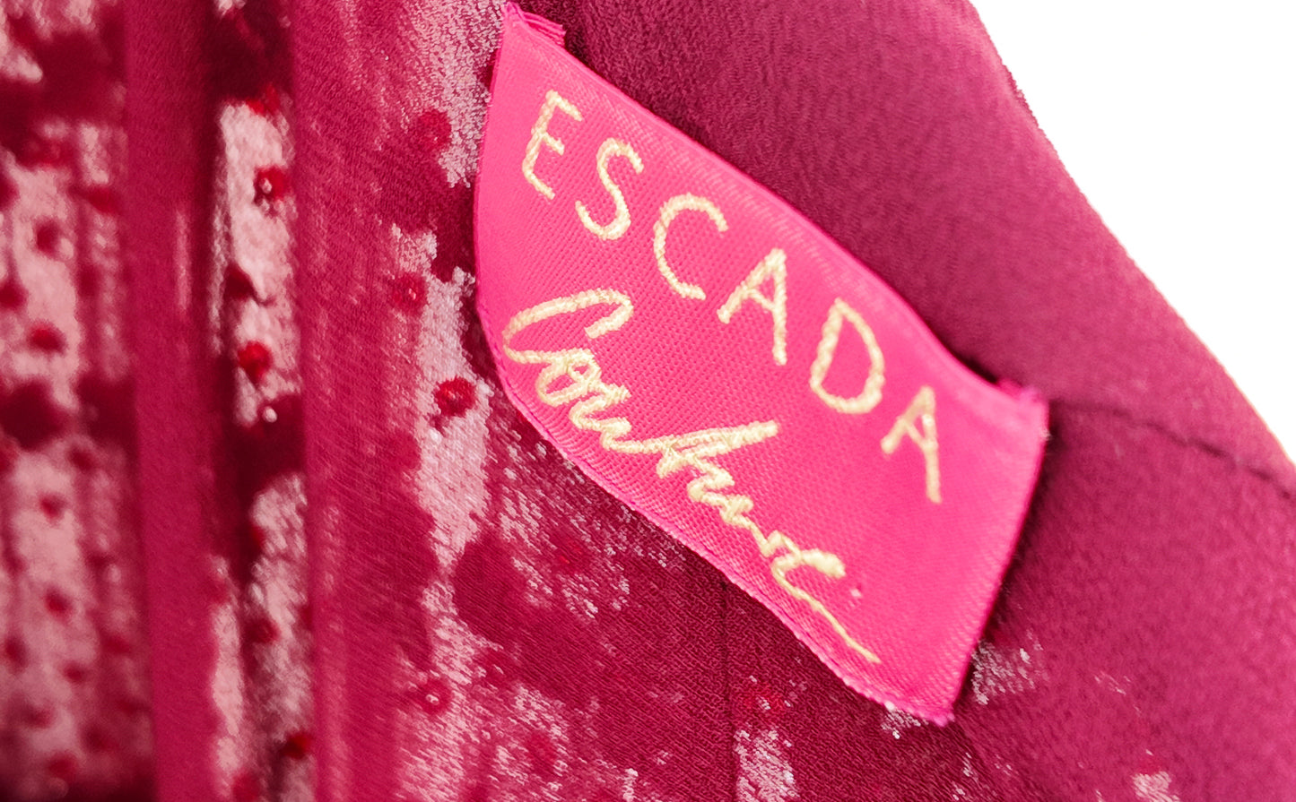 Close-up of a pink 'Escada' label on a garment with a white background