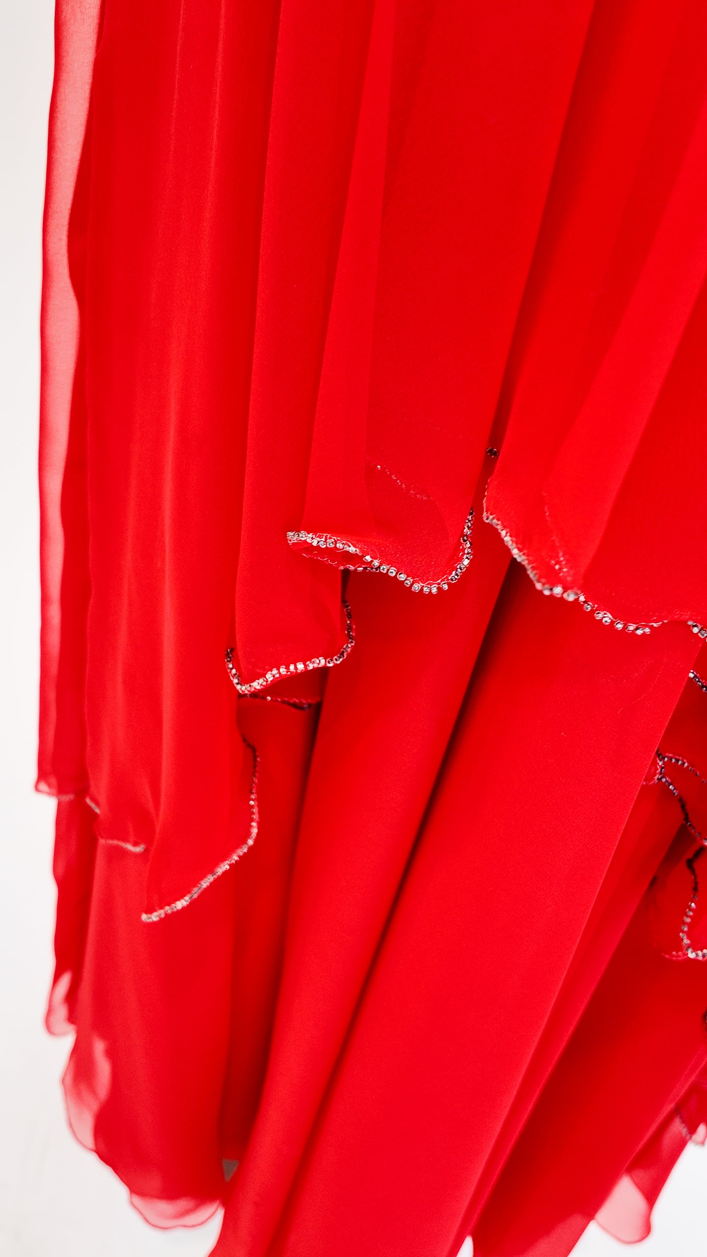 Red fabric with white rhinestone trim on a white background