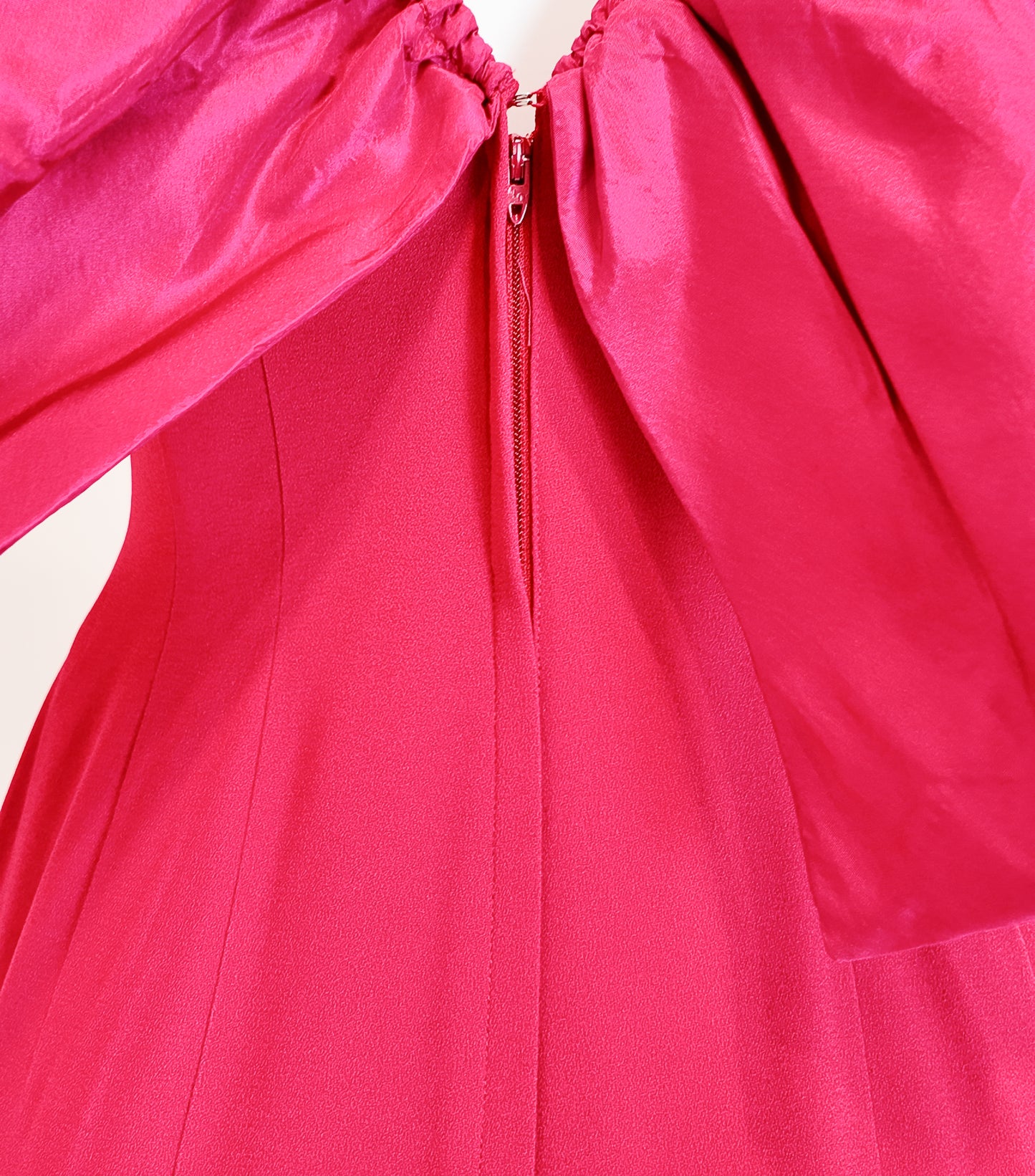 Close-up of a bright pink garment with a zipper on a white background