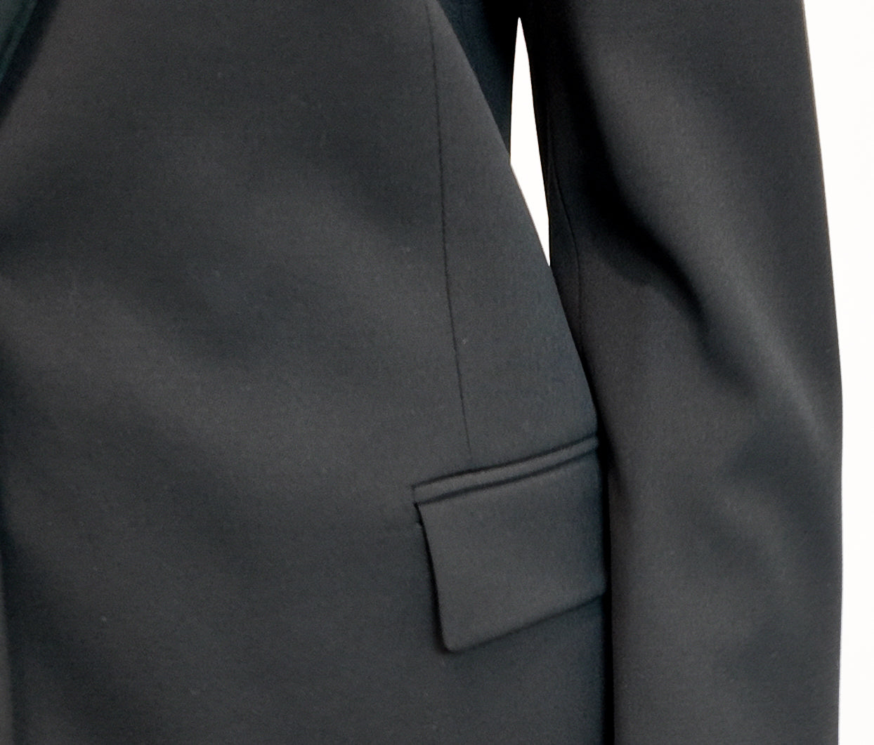 Close-up of a black suit jacket with a pocket detail on a white background