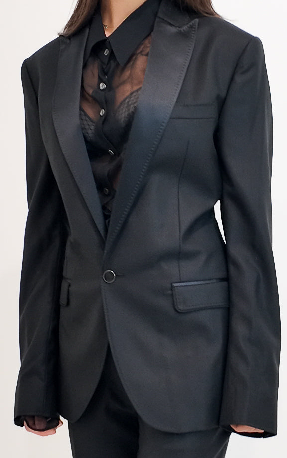 Black suit jacket worn by a person on a white background