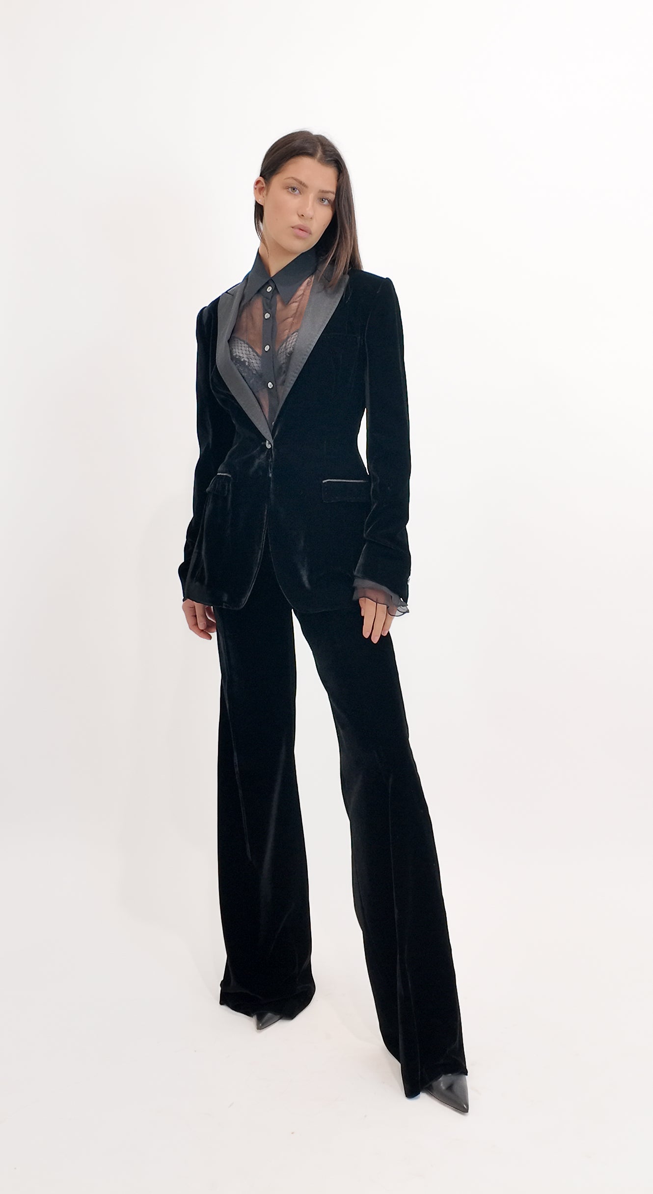 Person wearing a black velvet suit with a white background