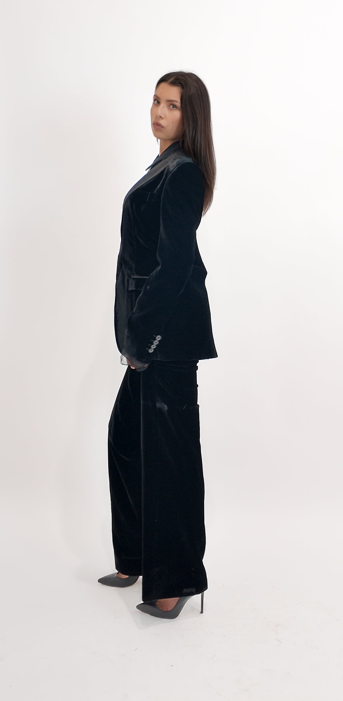 Person wearing a black velvet suit on a white background