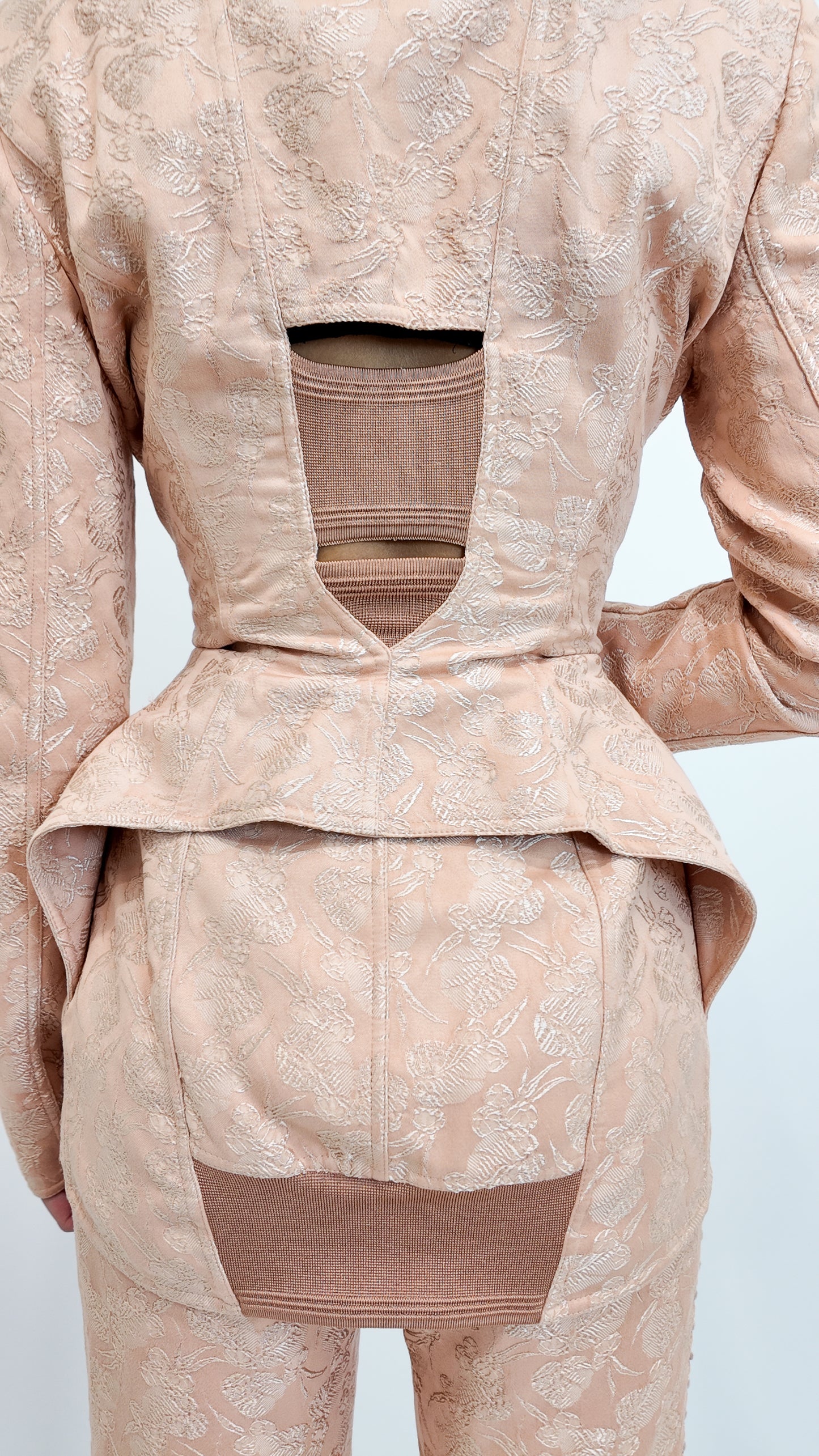Nude textured jacket and pants set on a white background