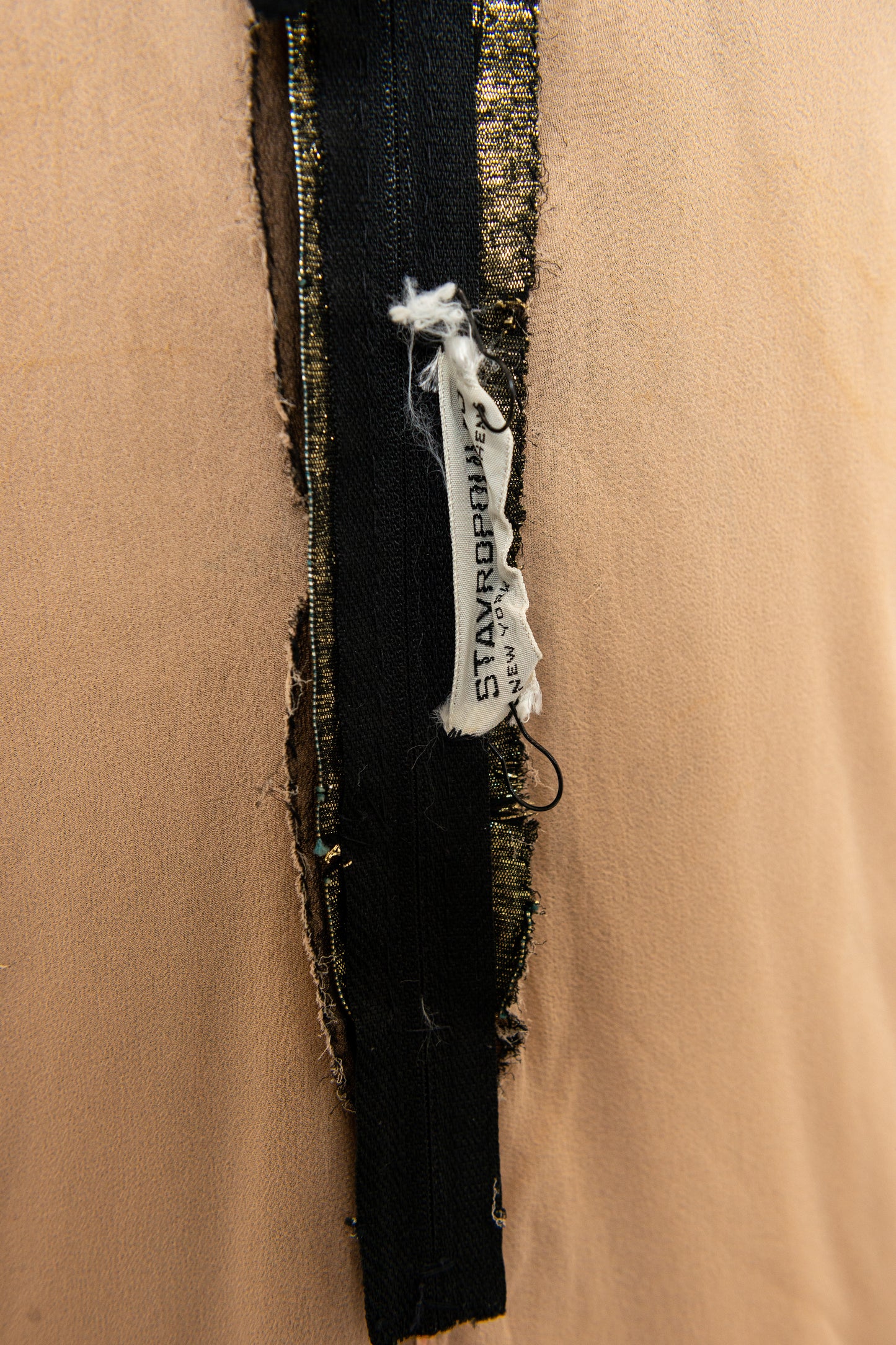 Close-up of a Stavropoulos garment brand tag on a beige background