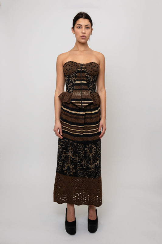 Woman wearing a strapless knit top with intricate patterns and a matching skirt on a white background