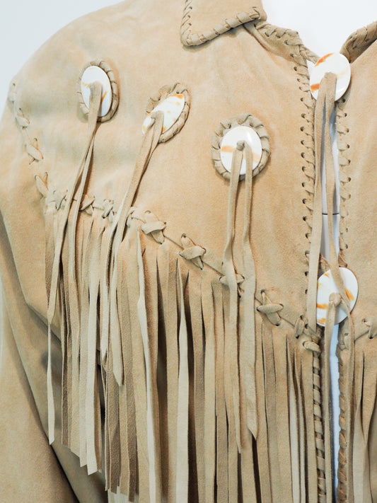 Close-up of a beige leather jacket with fringes and decorative elements on a white background