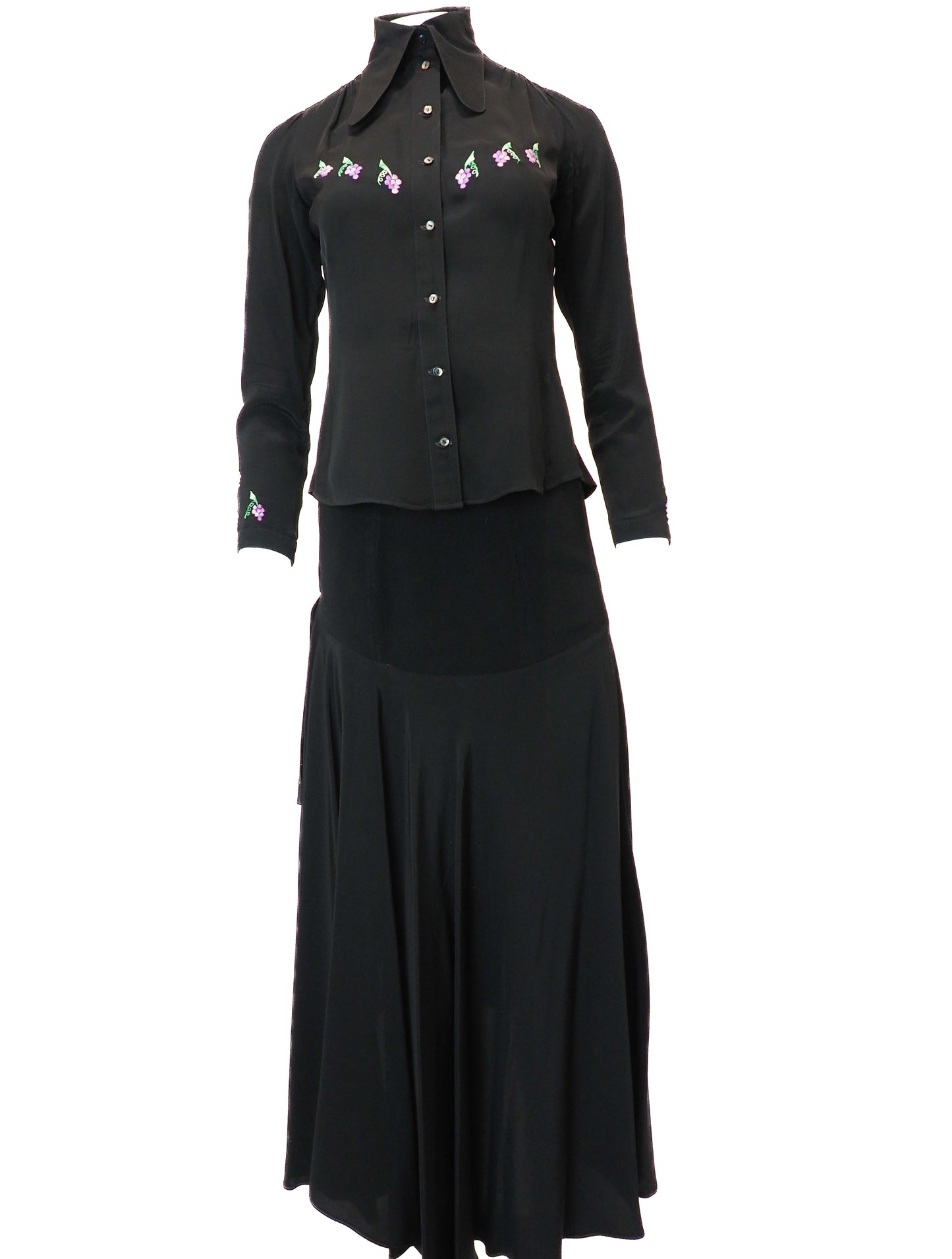 Black blouse with floral embroidery and black skirt on a white background