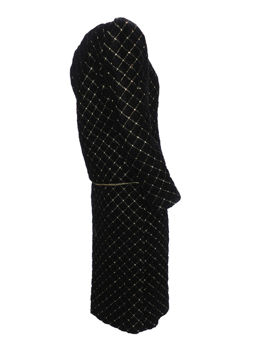 A vintage Celine black velvet two-piece suit set consisting of a cropped jacket and a matching pencil skirt, both decorated with a gold diamond lattice pattern and gold trim