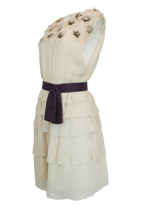 A vintage Chloe Y2K off-white sleeveless ruffled dress with floral embellishments on the bodice and a dark purple waist belt