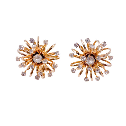 Gold sunburst earrings with clear stones on a white background