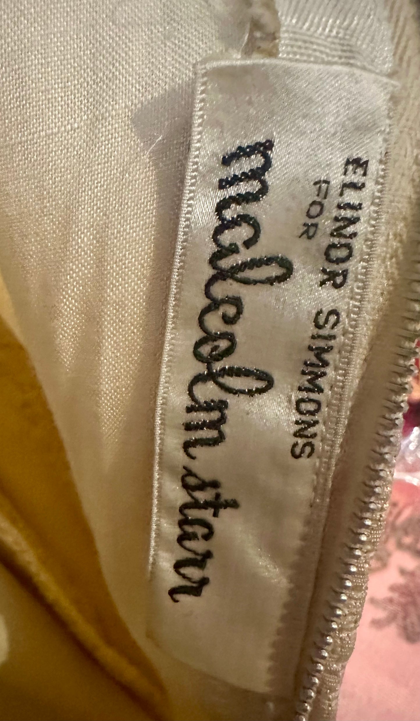 Label with 'malcolm star' and 'Elinor Simmons' text on a fabric background