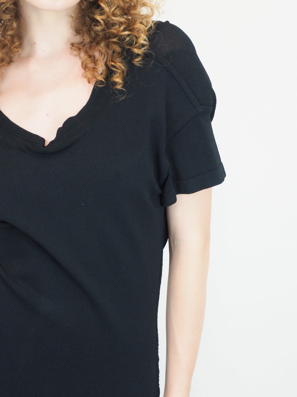 A vintage 1990s alaia black short-sleeve bodycon knit dress with back button details