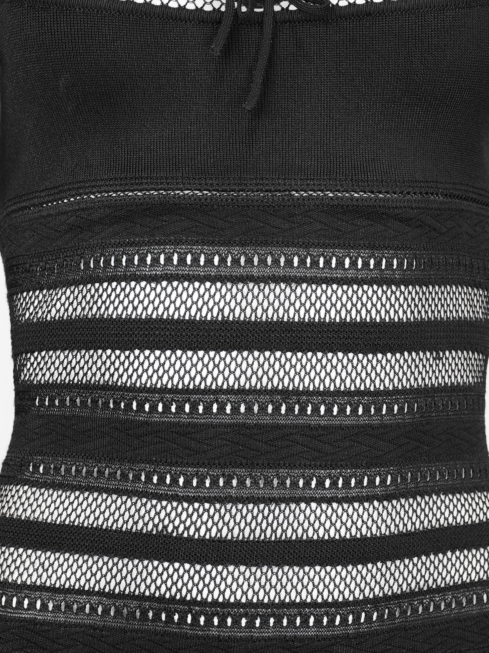 A vintage alaia 1993 black long-sleeve knit mini dress with horizontal openwork stripe patterns across the bodice, sleeves, and hem, featuring a scoop neckline with a front tie detail.