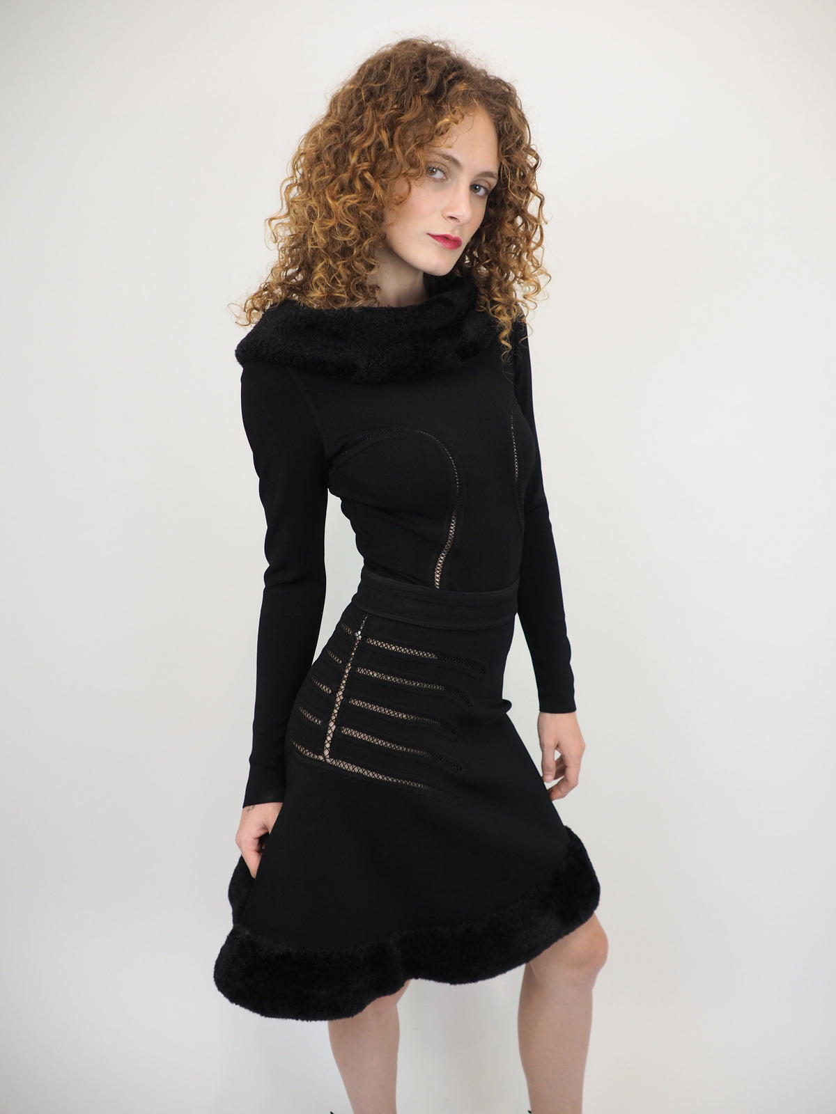 A vintage 1991 alaia black long-sleeve top and skirt set with a fuzzy collar and hem, featuring cut out seam curved trim details on the bodice and skirt