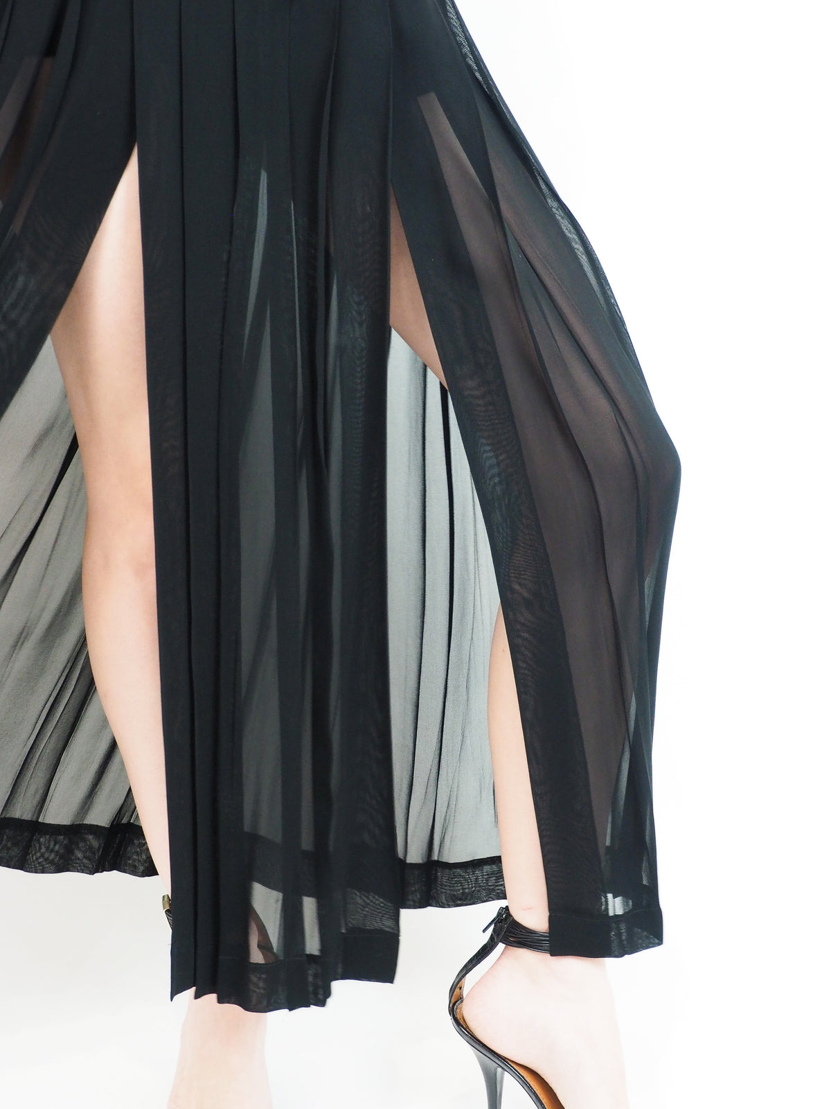 A vintage moschino black strapless high-low dress with a textured corset-style bodice, front cutout, and flowing sheer overlay skirt, paired with black heeled sandals