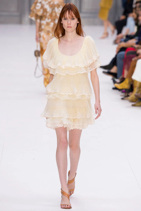 A vintage Chloe runway cream-colored tiered lace dress with ruffled eyelet trim and off-the-shoulder sleeves