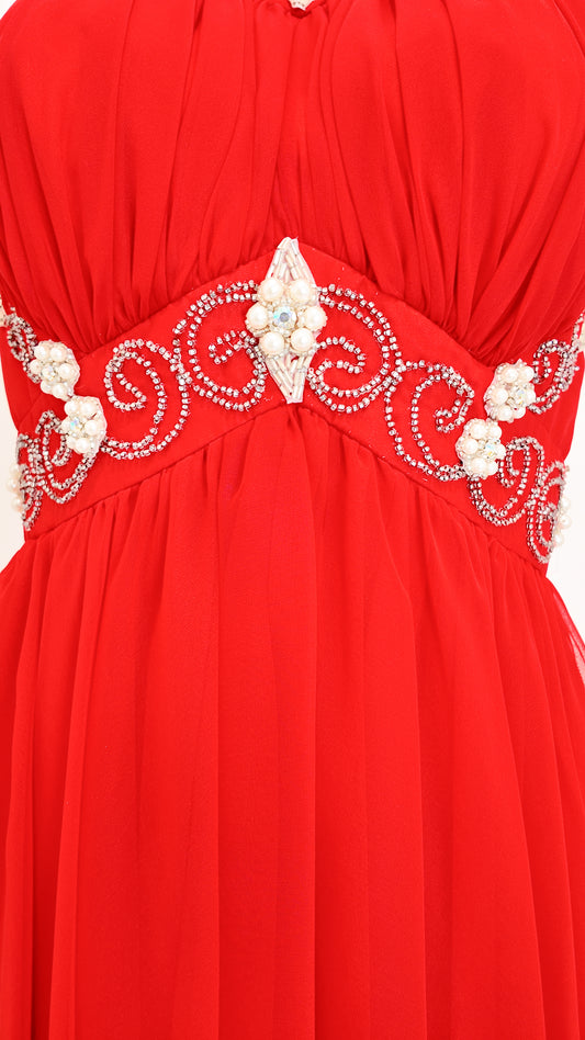 Red dress with intricate white embroidery on a white background