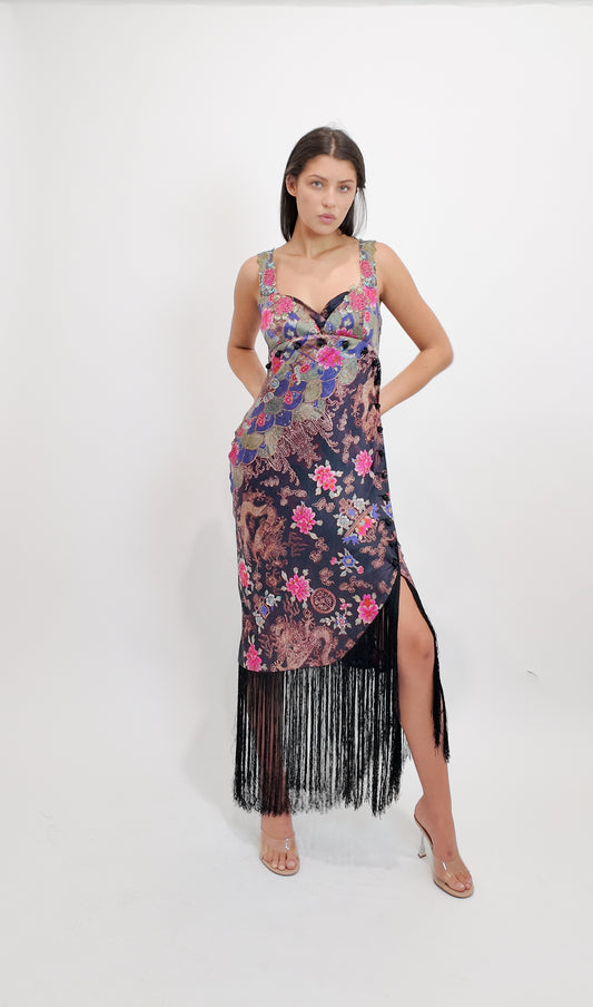 Woman wearing an ICEBERG floral dress with fringe details on a white background