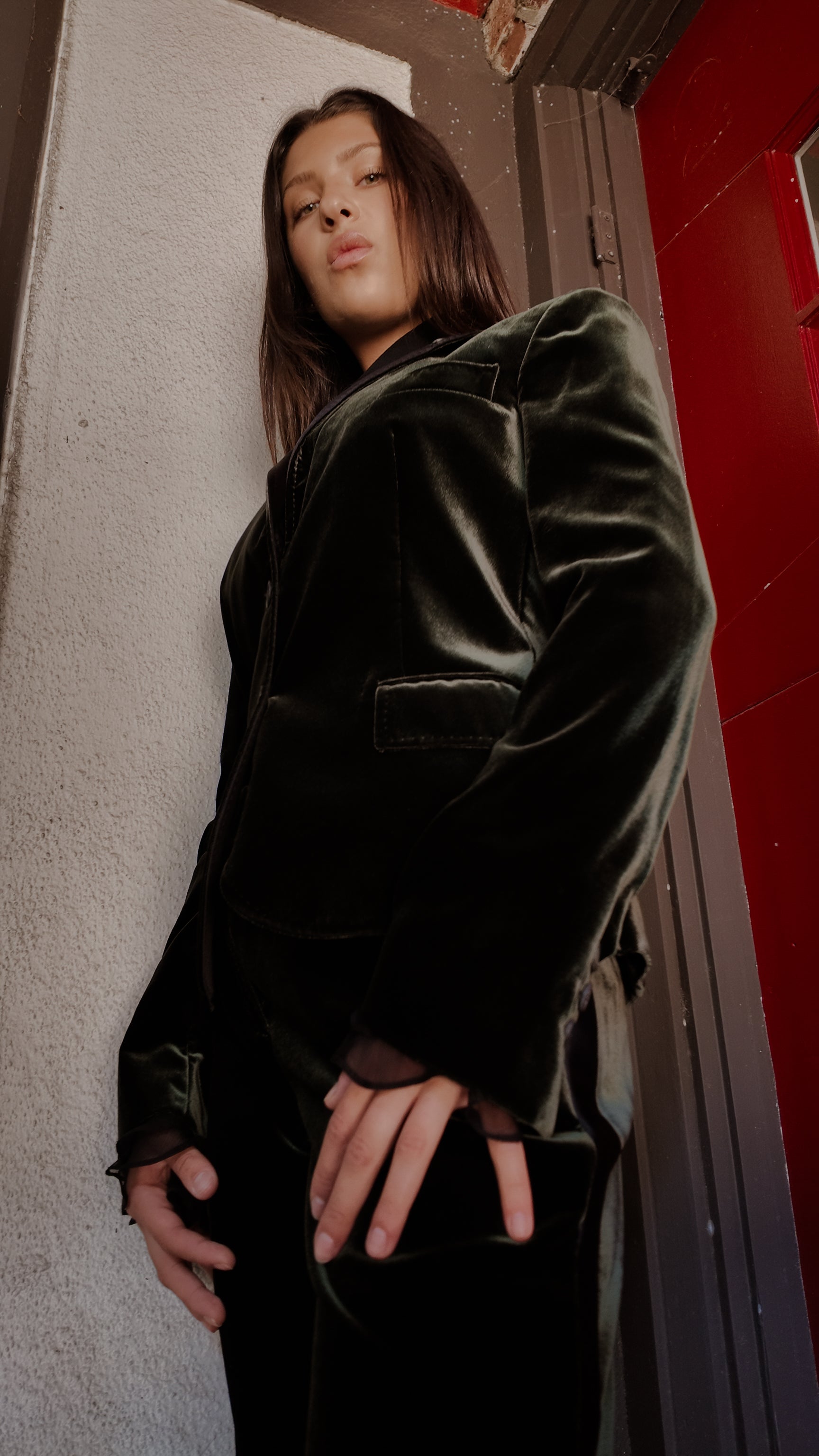 Woman wearing Tom Ford for Gucci 2007 green velvet tuxedo jacket against beige wall