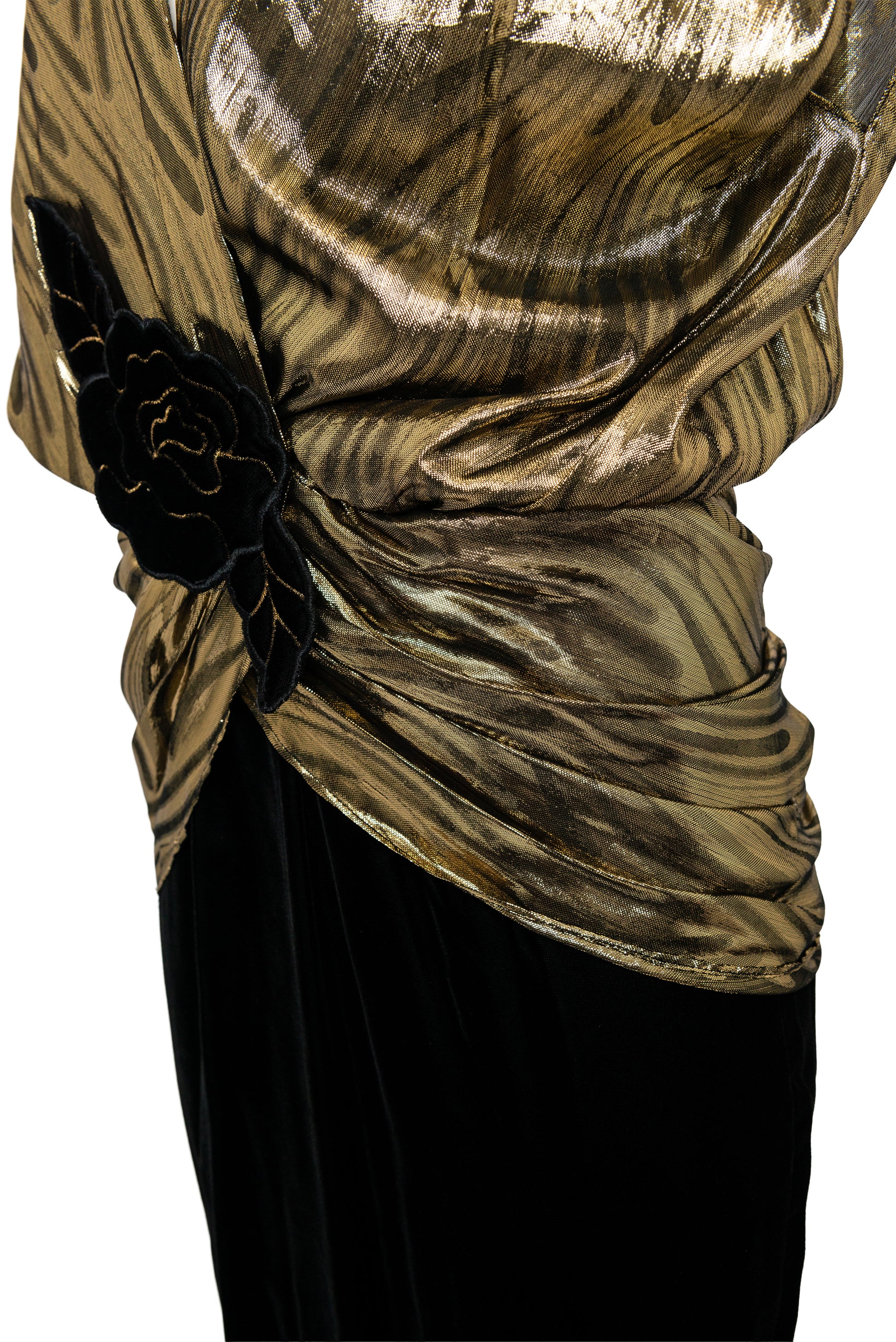 Gold and black patterned top with a black flower detail on a white background