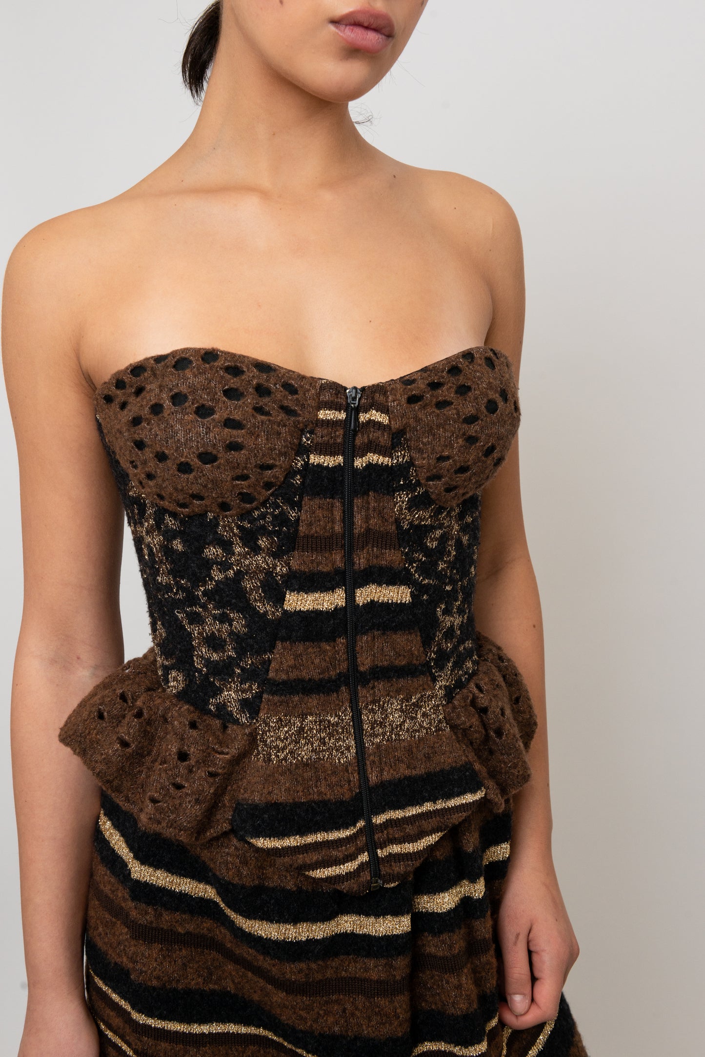 Brown strapless knit top with peplum detail on a plain background