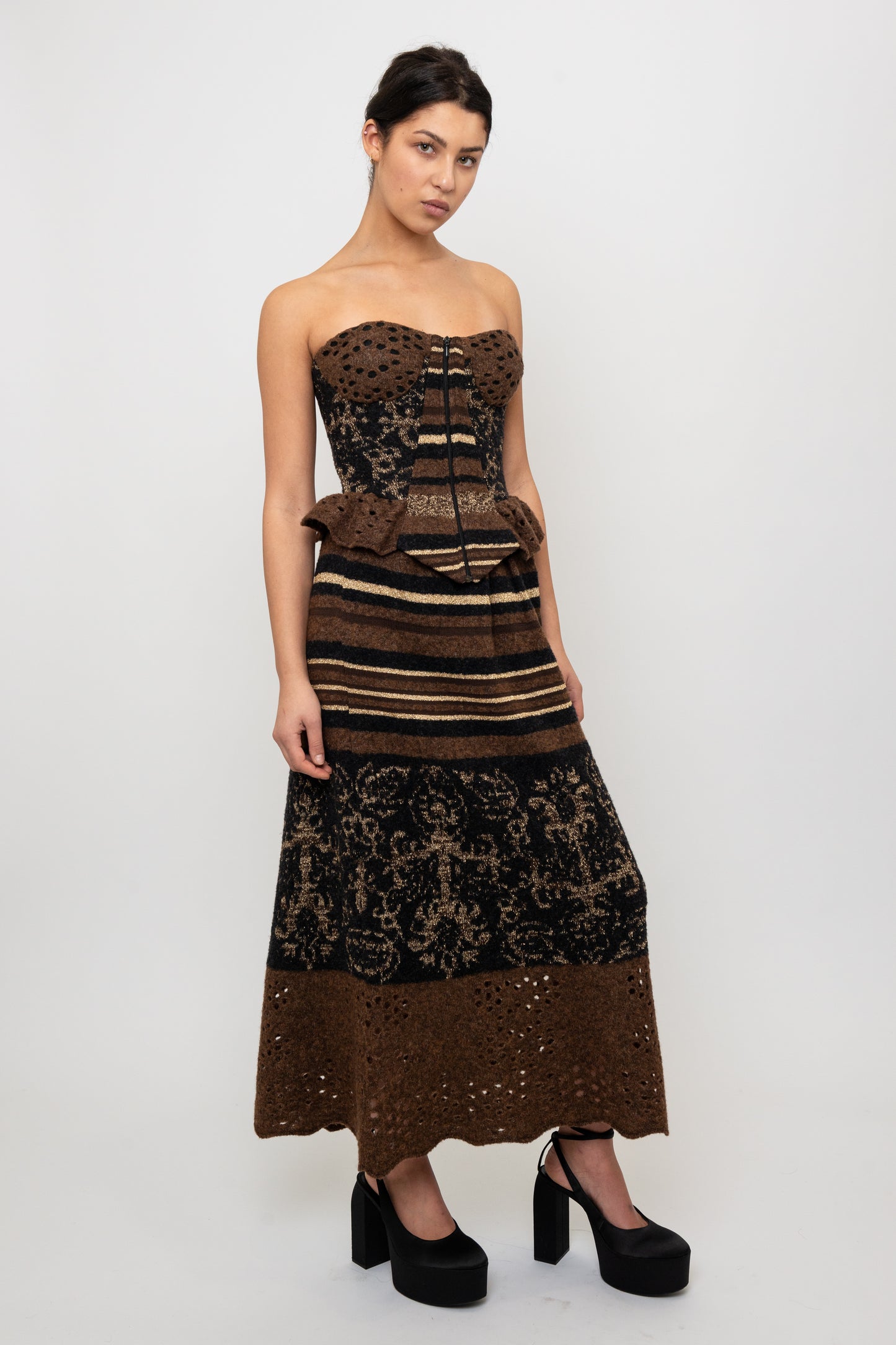 Woman wearing a strapless, striped patterned top with a matching skirt on a white background