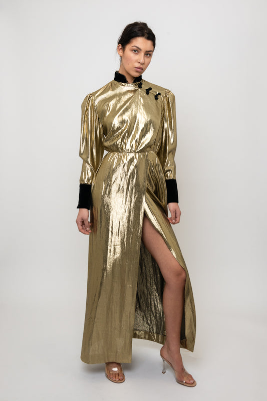 Woman wearing a gold metallic dress with black accents on a white background