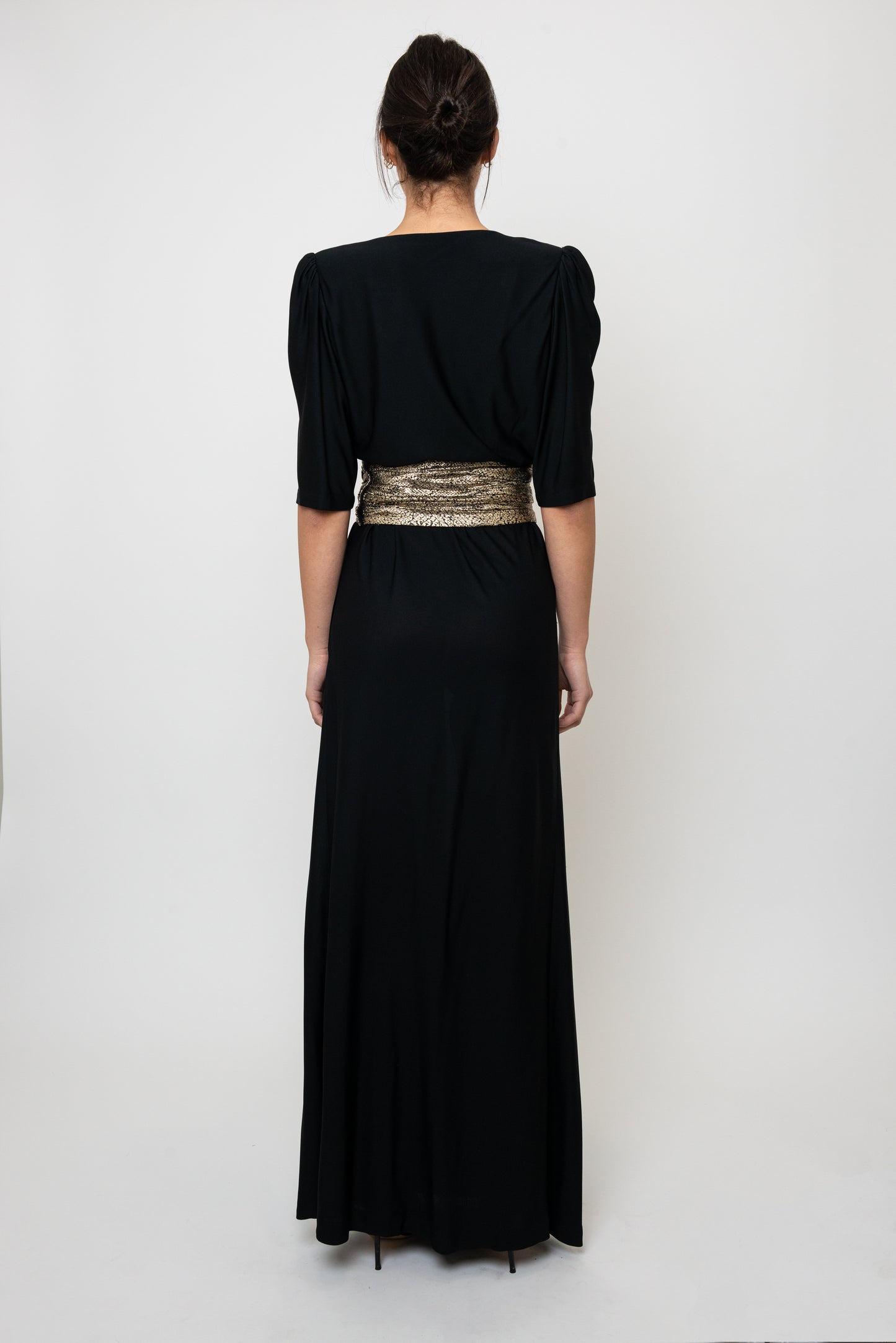 Black dress with a gold waistband on a white background