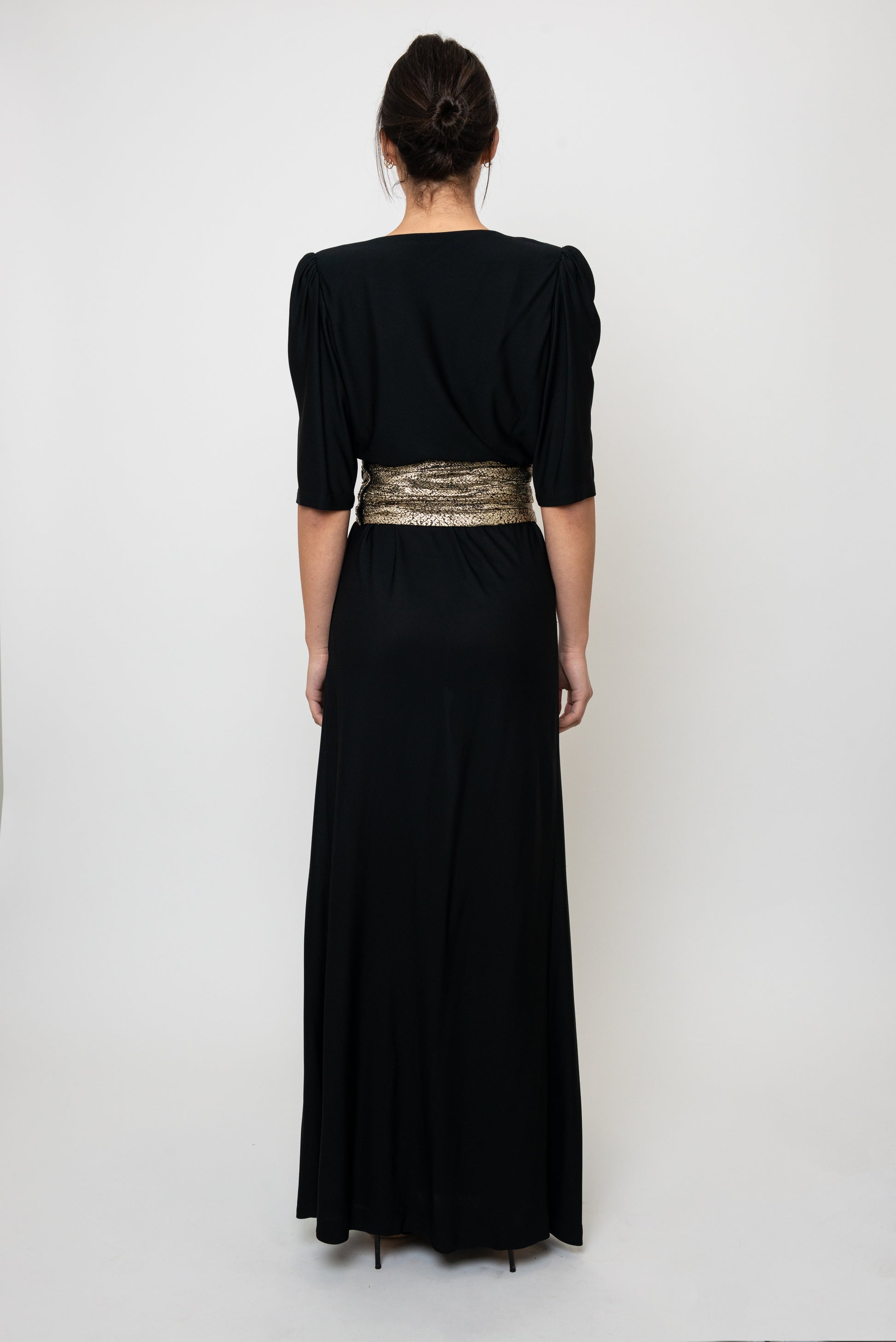Black dress with a gold waistband on a white background