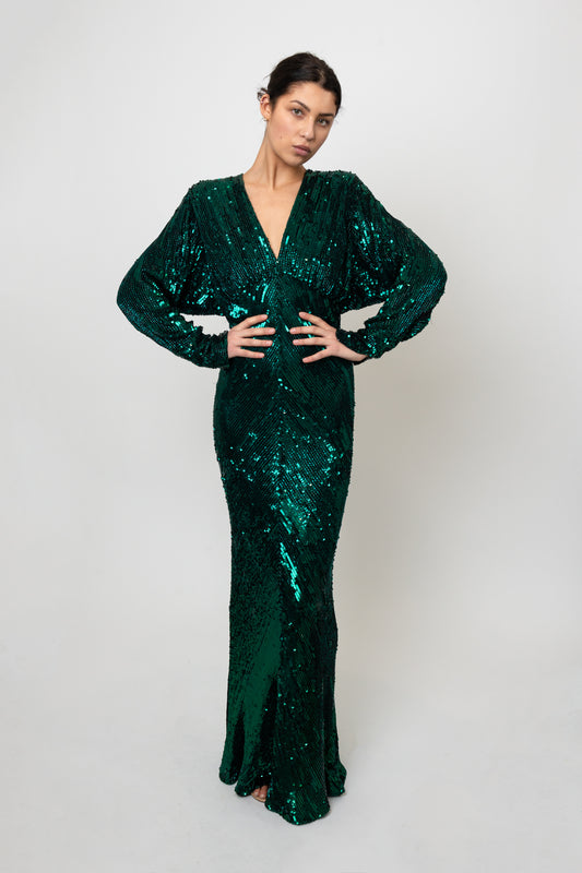 Woman wearing a green sequin dress against a white background