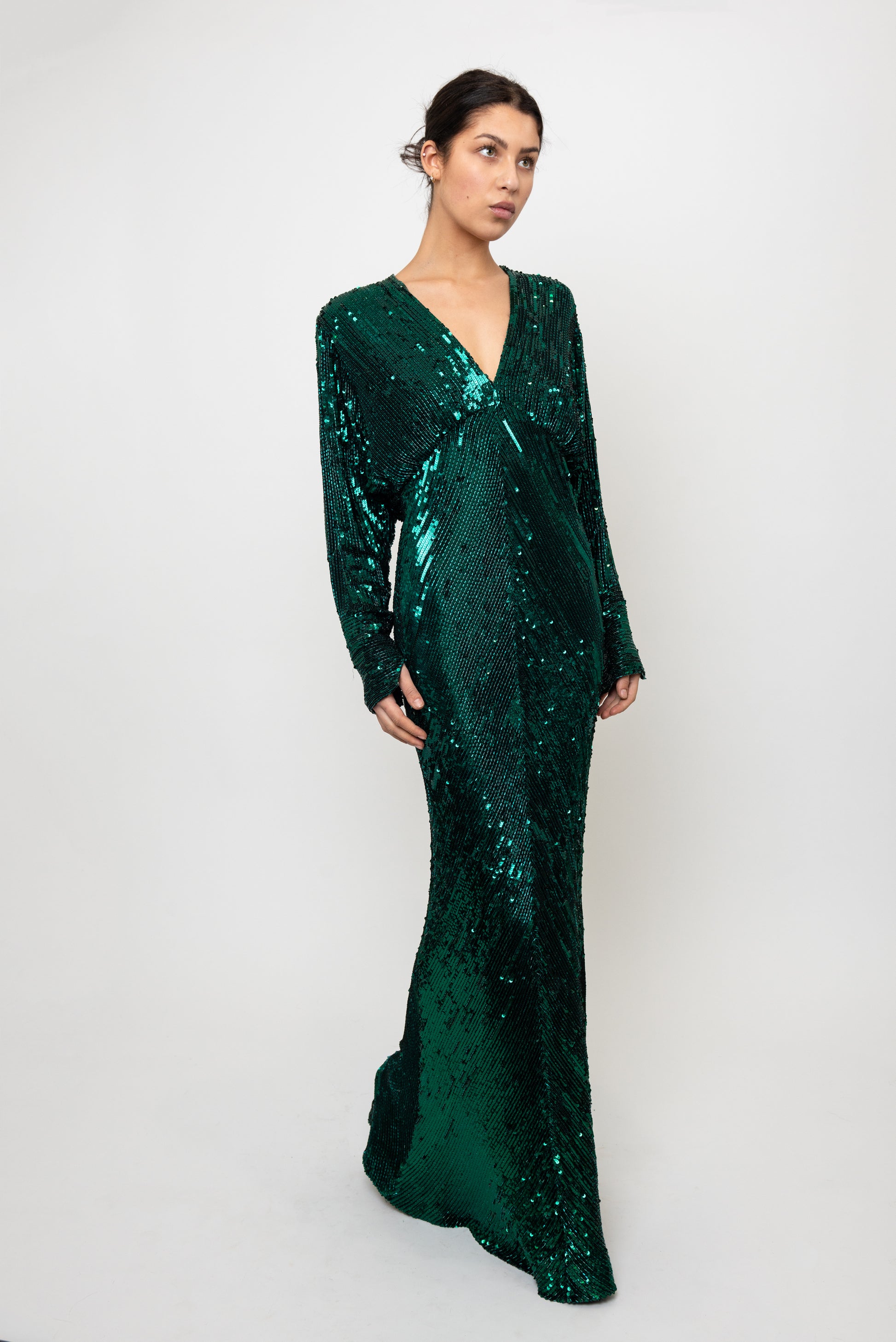 Woman wearing a green sequin dress against a white background