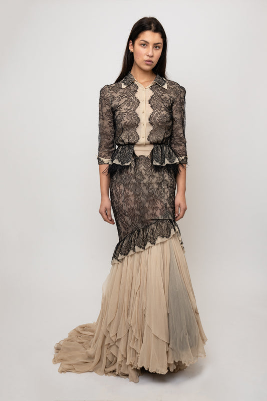 Woman wearing a lace dress with a fitted bodice and flowing skirt on a white background