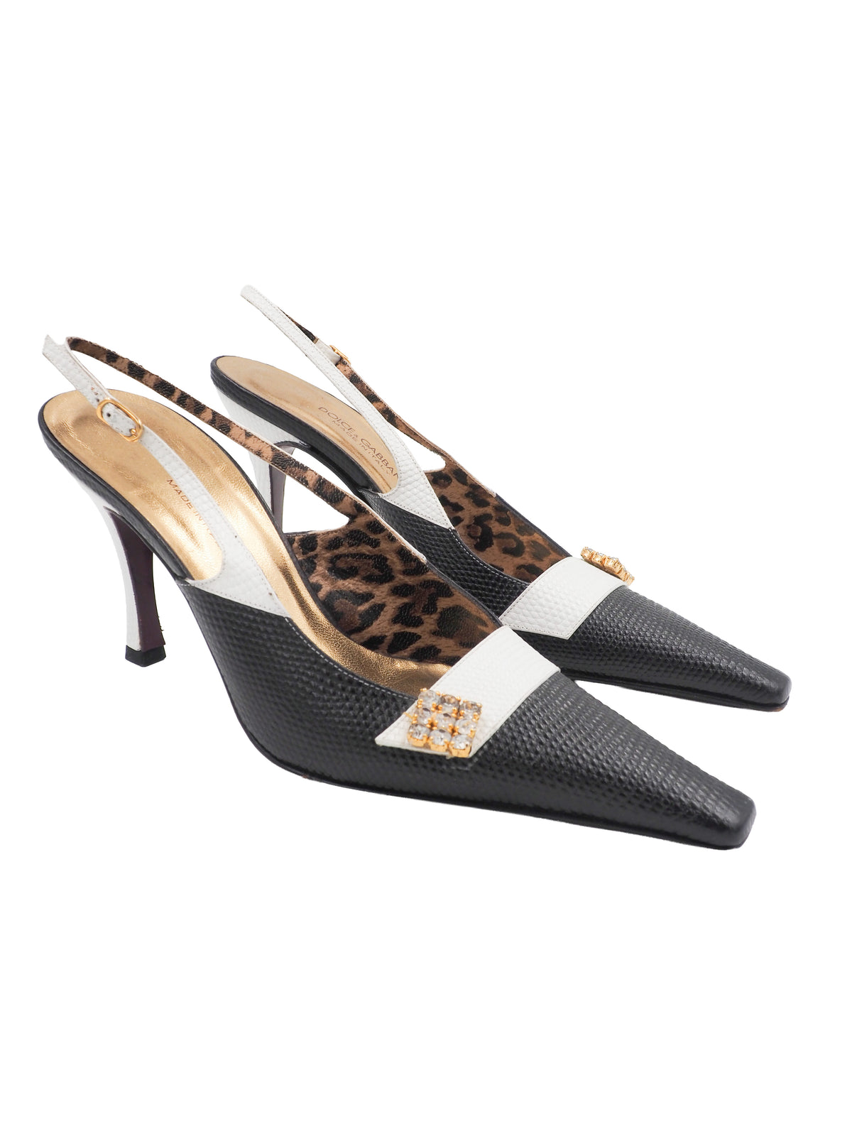 A pair of vintage dolce and Gabbana pointed-toe slingback heels featuring a black textured leather toe, a white midfoot strap with a rhinestone square, and a leopard-print lining
