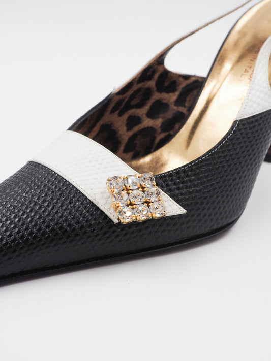 A pair of vintage dolce and Gabbana pointed-toe slingback heels featuring a black textured leather toe, a white midfoot strap with a rhinestone square, and a leopard-print lining