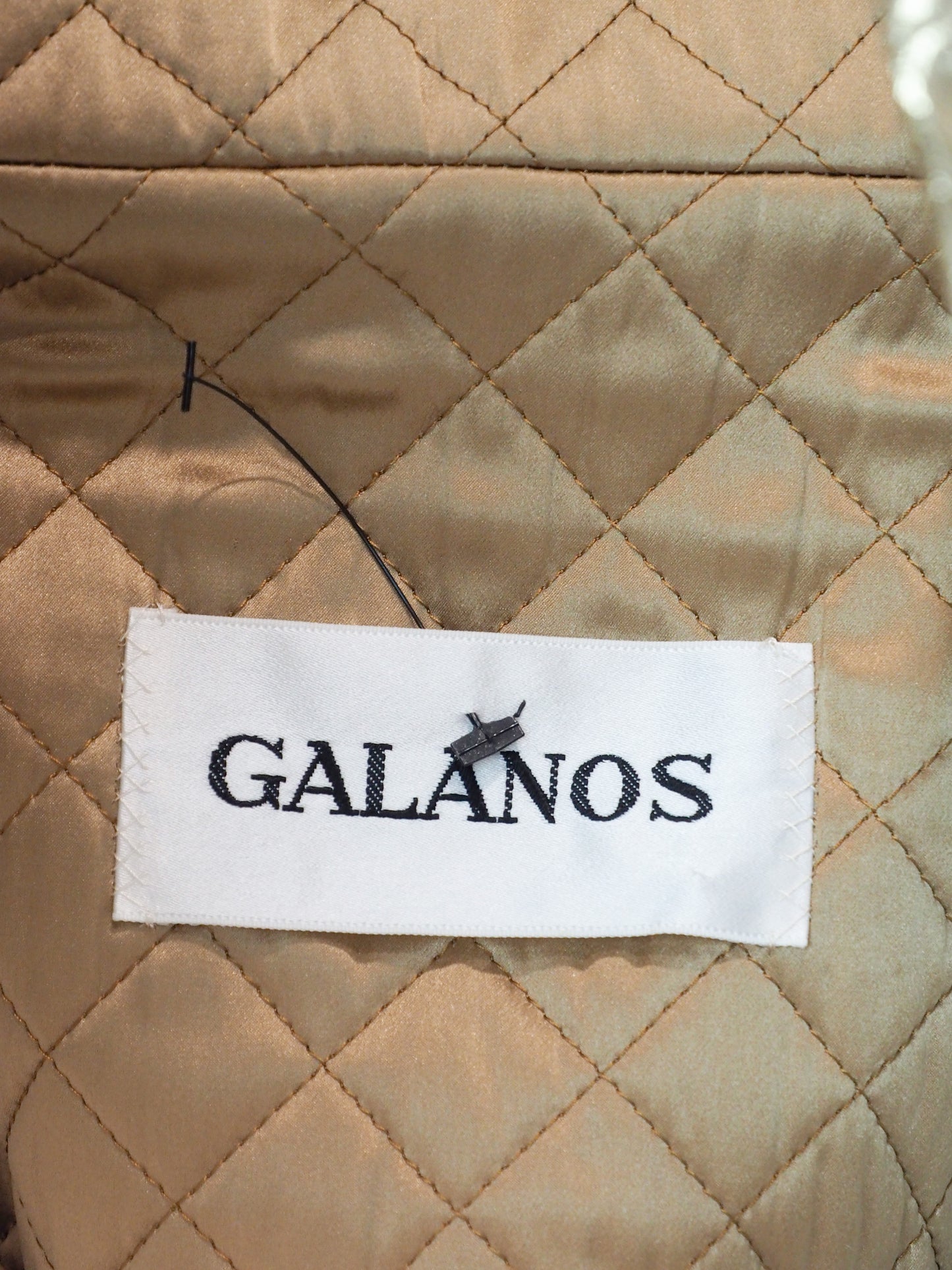 A vintage James galanos metallic gold textured coat with a high stand collar, front zipper, and side pockets