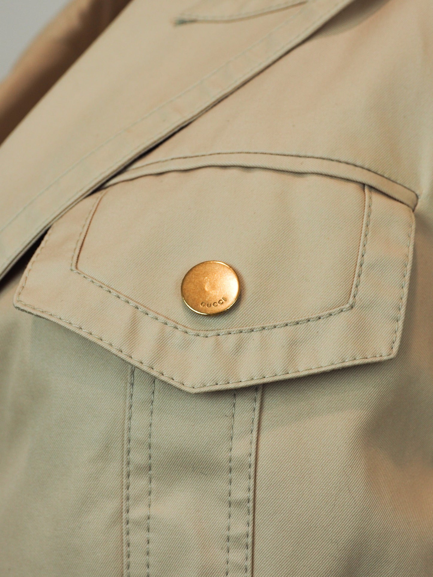 A women's vintage Tom Ford Gucci 2003 beige utility-style blazer jacket with a notched lapel collar, buttoned flap chest pockets, a gathered waist seam, and two large front flap pockets