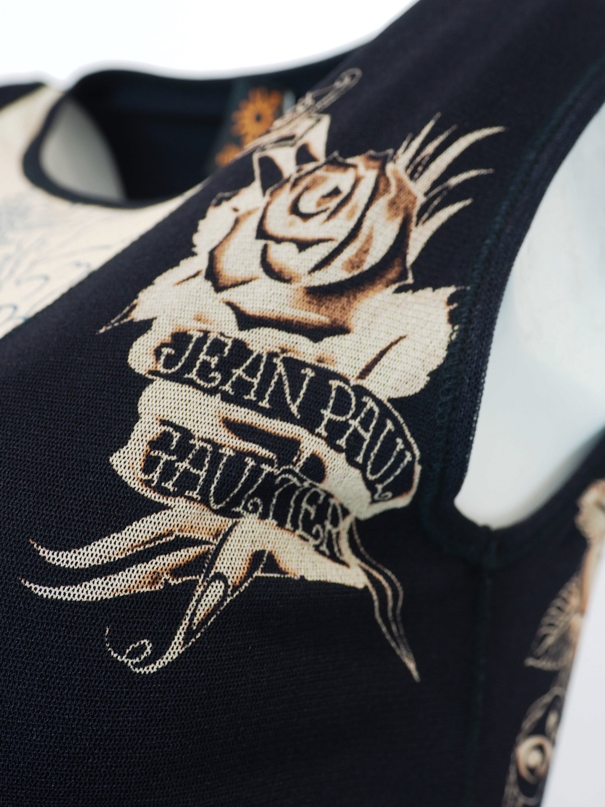 A vintage jean Paul gaultier mesh sleeveless black midi dress featuring a large beige and gold dragon graphic print on the front, with a sheer hem
