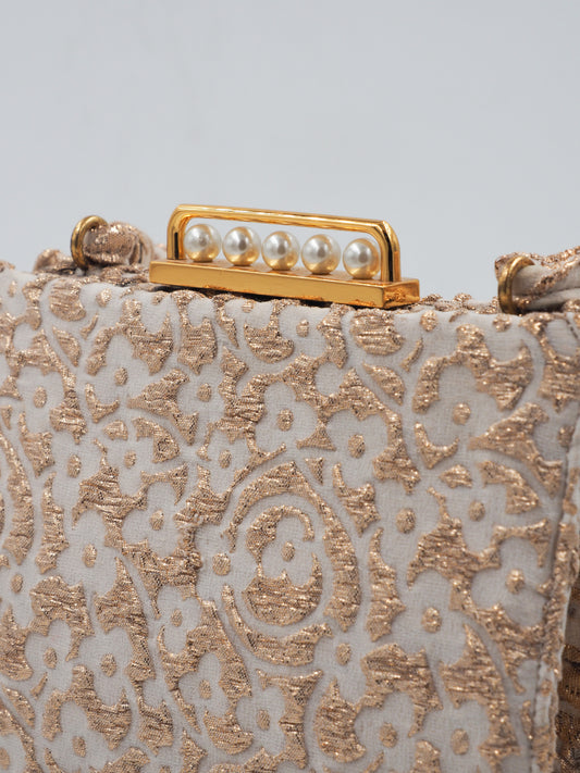 A 1960s Koret vintage structured evening clutch bag in beige and gold lace, featuring a braided top handle and a gold-tone metal clasp adorned with faux pearls