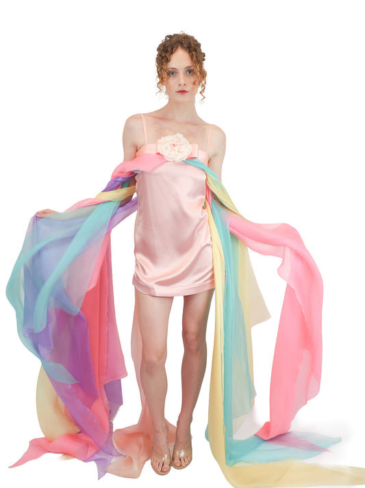 A vintage Pierre Cardin pastel rainbow tulle dress with a high-low hemline, a pink fabric flower at the bust, and a long flowing train 