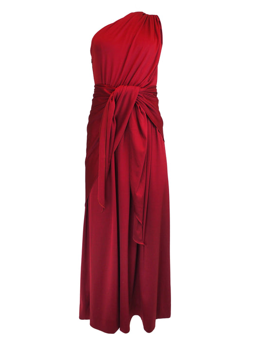 A vintage 1970s red one-shoulder maxi dress with a draped, wrap-style bodice and a matching waist tie