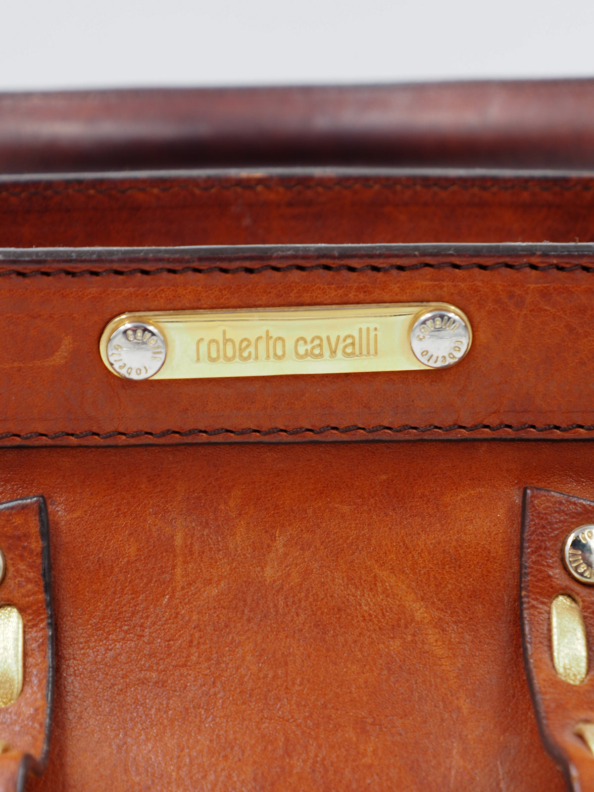 A vintage Roberto cavalli brown leather duffel-style handbag with rope handles and gold-tone hardware