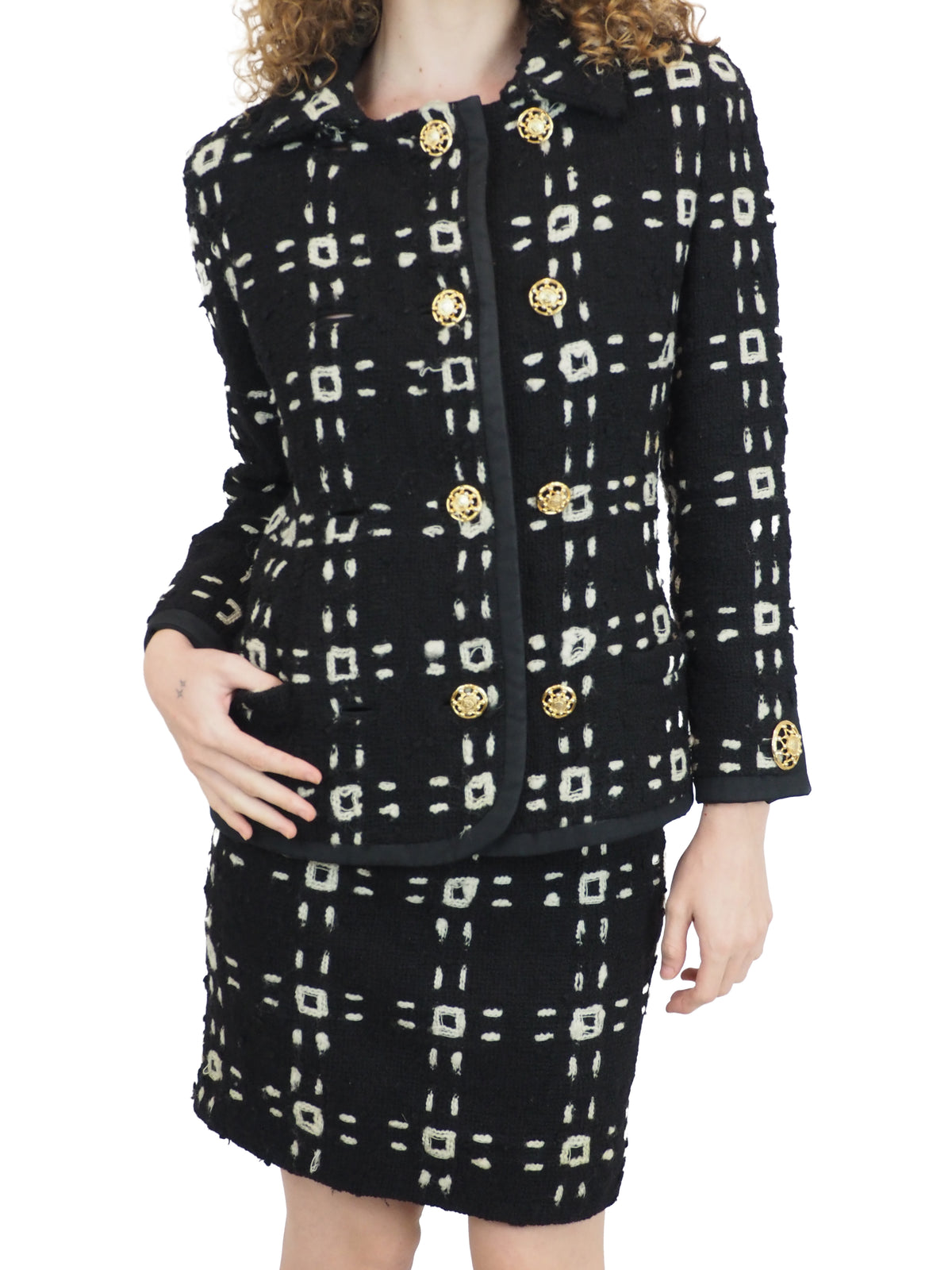 A vintage 1992 Gianni Versace black tweed jacket and matching mini skirt set with a beige geometric pattern and gold buttons
