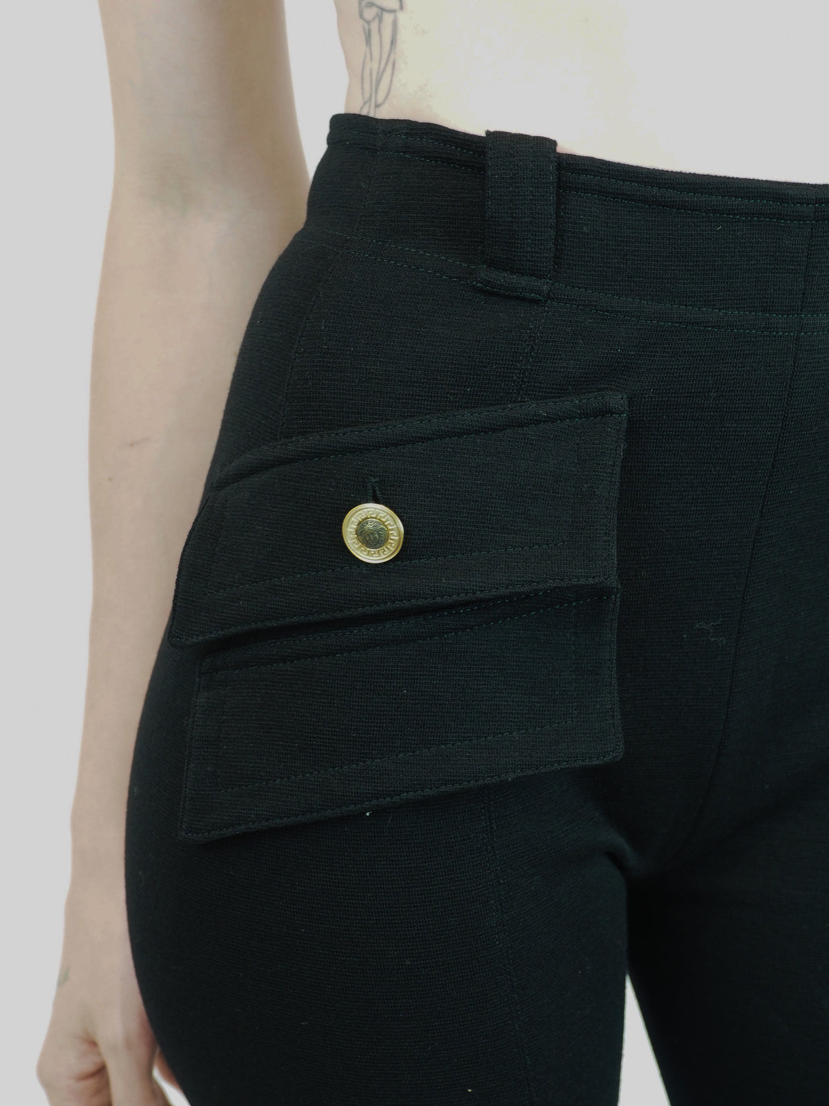 Black vintage Versace high-waisted skinny pants with flap pockets and gold medusa button details