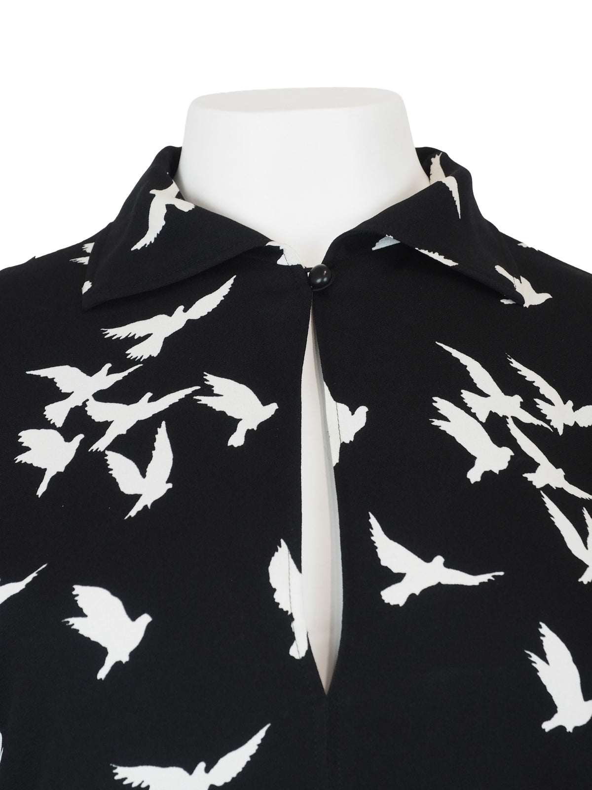 A vintage Yves Saint Laurent YSL 1970's black short-sleeve midi dress with a white bird pattern