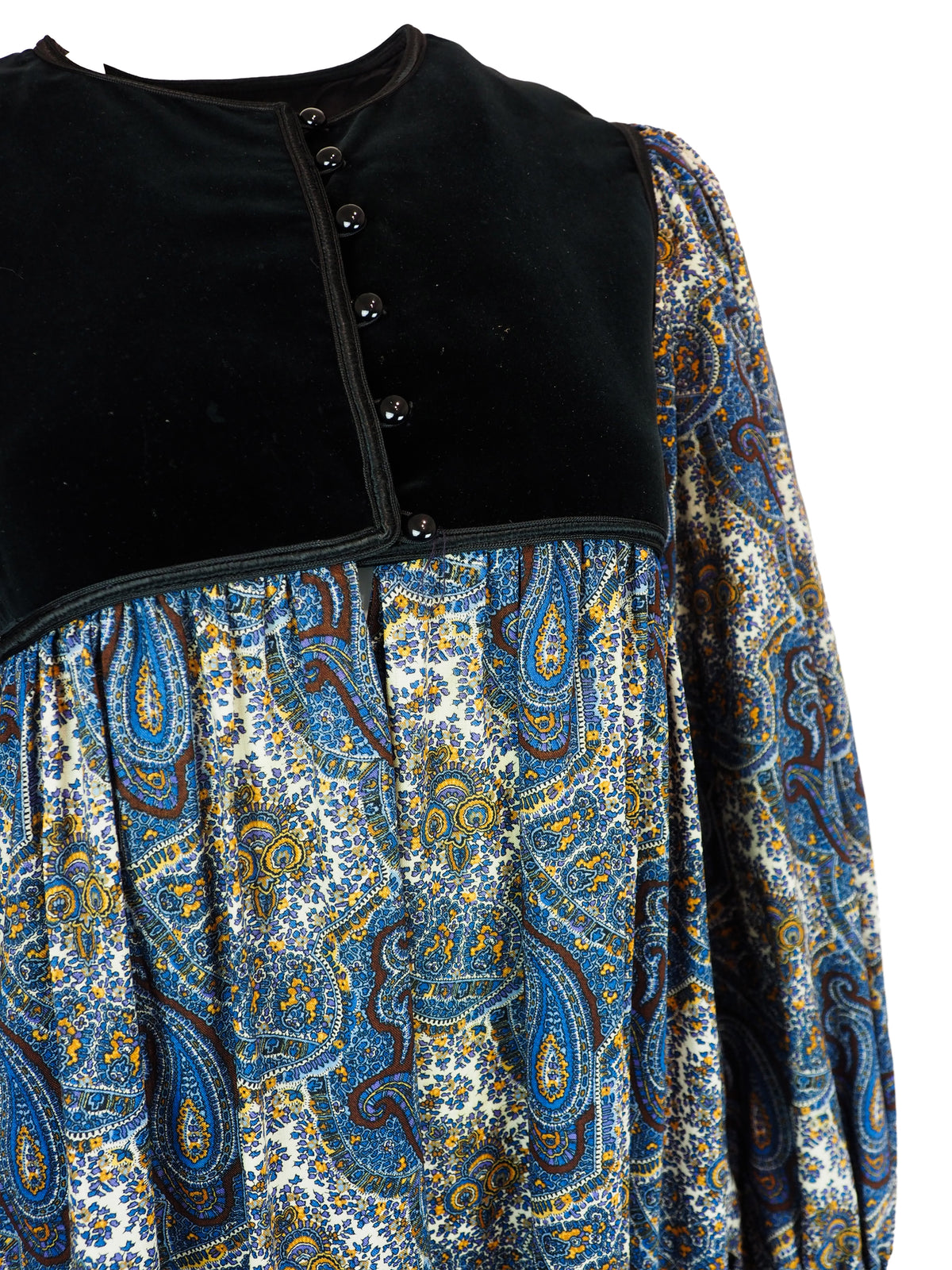 A 1976 Yves Saint Laurent Ballet Russes  long-sleeve midi dress with a black velvet yoke and cuffs, and a blue, gold, and white paisley patterned skirt