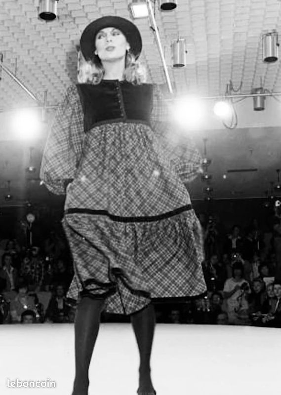 A 1976 Yves Saint Laurent Ballet Russes  long-sleeve midi dress with a black velvet yoke and cuffs, and a blue, gold, and white paisley patterned skirt